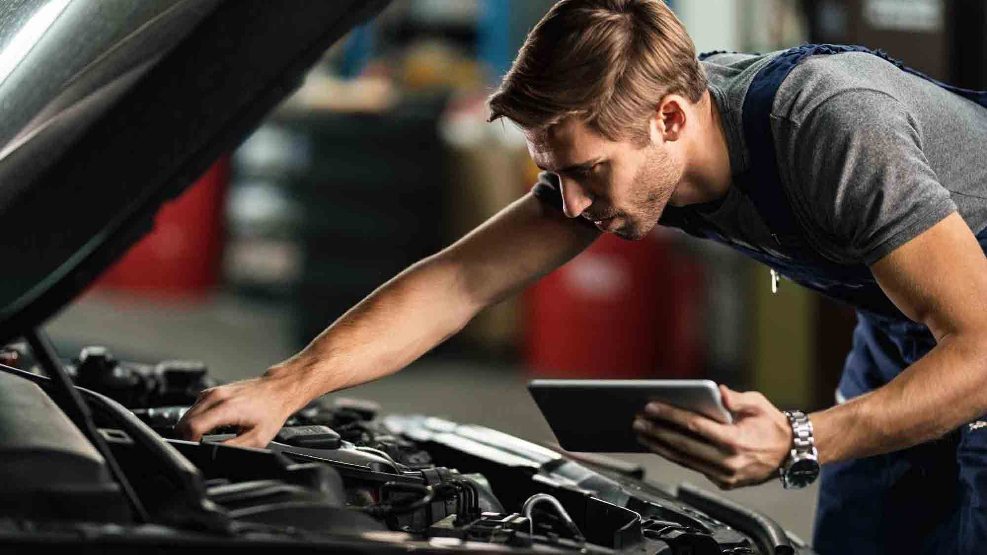 car-mechanic-examining-engine-malfunction-while-using-touchpad-auto-repair-shop.jpg